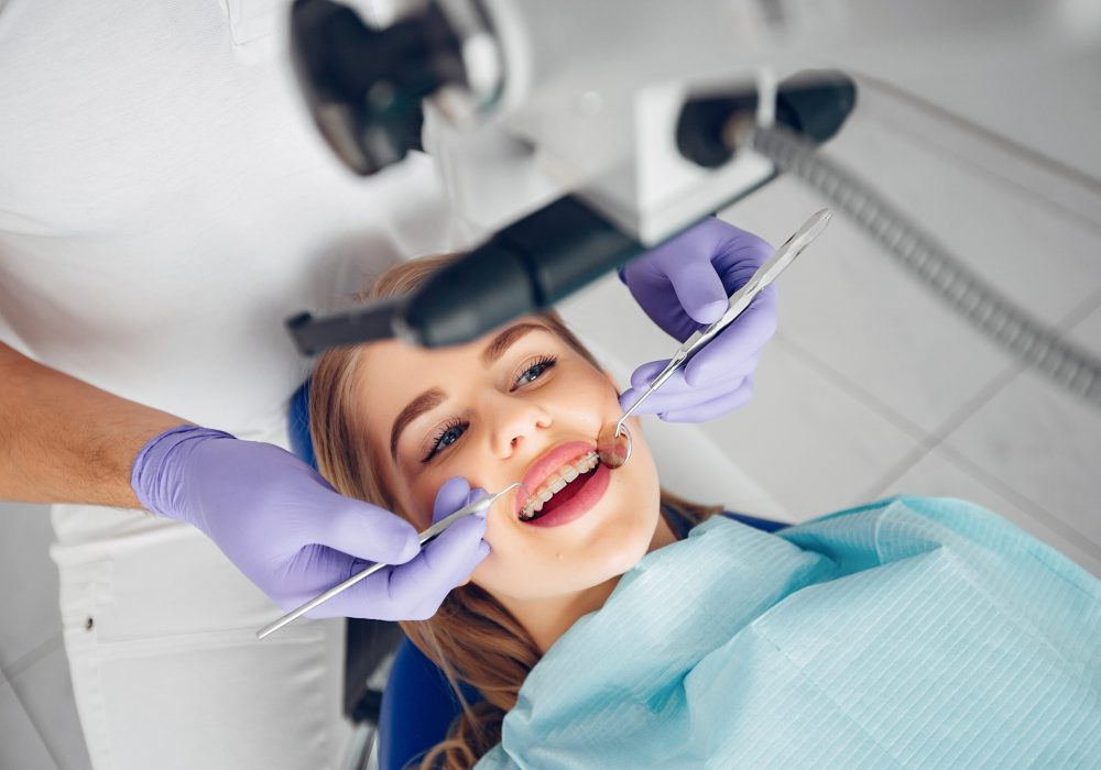 Beautiful girl sitting in the dentist’s office Beautiful lady in the dentist's office. Woman in a uniform